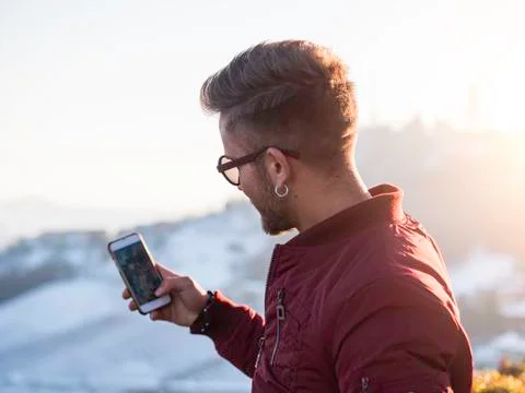 Young man using cell phone outdoor in winter fashion Stock Photos