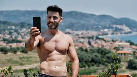 Young man using cell phone to take selfie Stock Photos