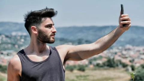 Young man using cell phone to take selfie Stock Photos