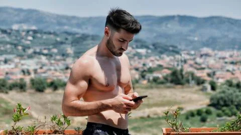 Young man using cell phone to send message Stock Photos
