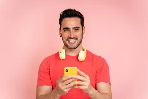 Young man using cell phone and headphones in studio. Stock Photos