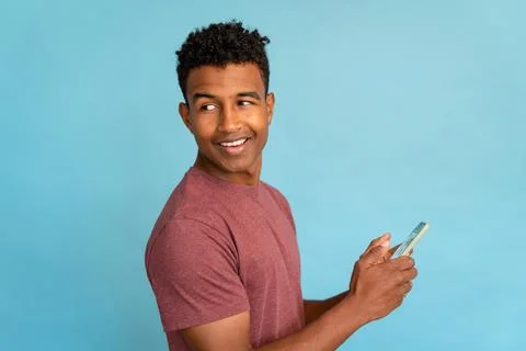 Young man using cell phone in studio shot. Stock Photos