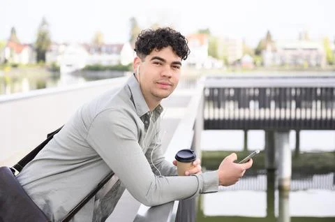 Young man using cellphone and headphone on the street Stock Photos