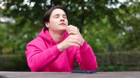 Young man using cellphone software applications sitting at table,dissatisfied Vidéo 253827665