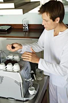 Young man using coffee maker Stock Photos
