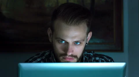 Young man using computer in the darkness: searching on the web, and chatting Stock Footage 42987233