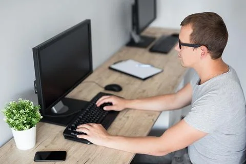 Young man using computer at home or at work - blank screen with copy space Stock Photos