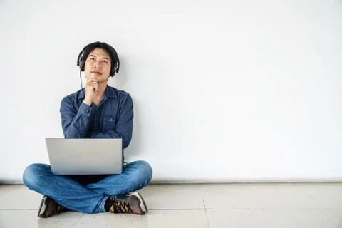 Young man using computer laptop and listening data in feel doubting  thinking Stock Photos