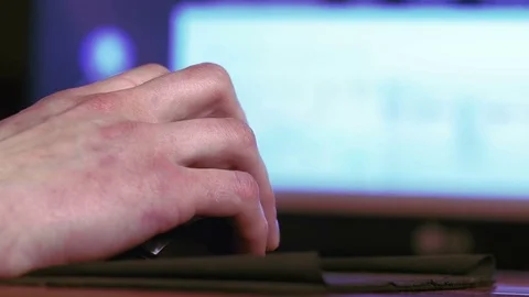 Young man using computer mouse sitting by the table at home Stock Footage
