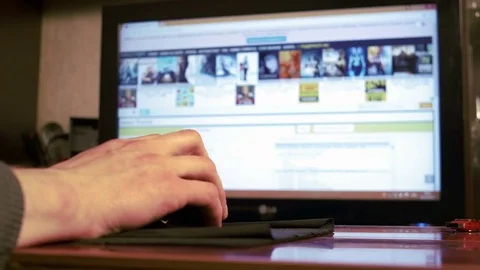Young man using computer mouse sitting by the table at home Stock Footage 74982125
