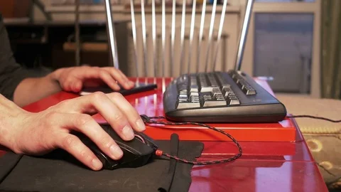 Young man using computer mouse sitting by the table at home Stock Footage 74987397