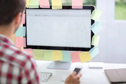 Young man  using computer with notes on it Stock Photos
