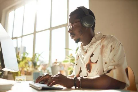 Young Man using Computer in Sunlight Stock Photos