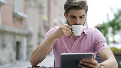 Young man using digital tablet at outdoors cafe Stock Footage 102384976