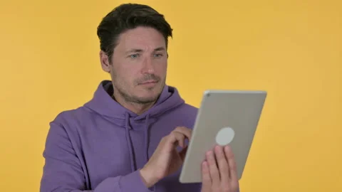 Young Man using Digital Tablet, Yellow Background 스톡 동영상 141683889