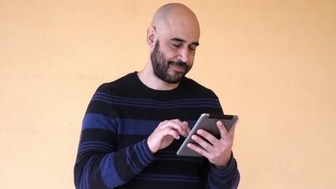 Young man using digital tablet isolated on yellow background Stock Footage 187171635