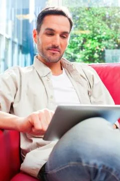 Young man using digital tablet on sofa Stock Photos