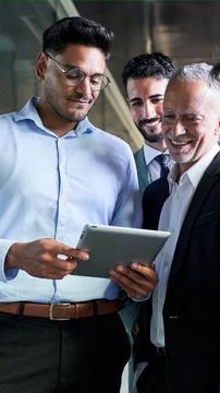 Young man using a digital tablet showing his project to his boss and colleagues Stock Photos