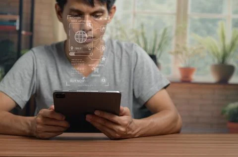 Young Man Using Digital Tablet with Virtual Interface in Modern Indoor Space Stock Photos