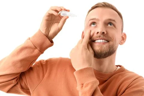 Young man using eye drops on white background, closeup Stock Photos