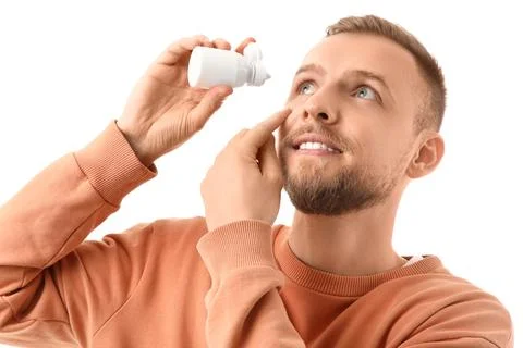 Young man using eye drops on white background, closeup Stock Photos