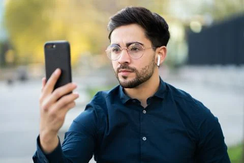 Young man using face id for unlock mobile phone outdoors. Stock Photos