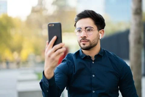 Young man using face id for unlock mobile phone outdoors. Stock Photos