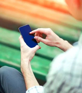 Young man is using frameless screen smartphone in the city close-up Stock Photos