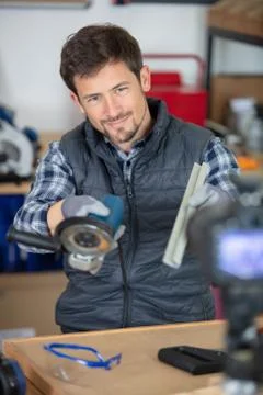 Young man using grinder in workshop Stock Photos