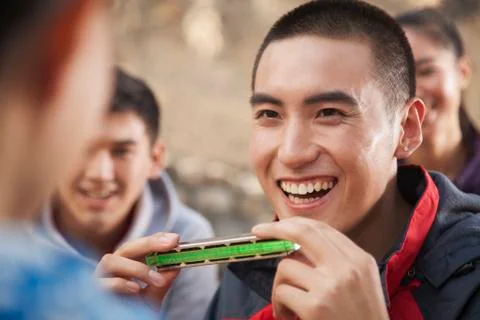 Young man using harmonica, portrait Stock Photos