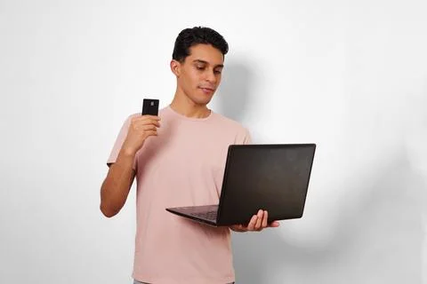 Young man using his card in online shopping Stock Photos