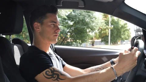 Young Man Using his Cell Phone Driving Car Stock Photos