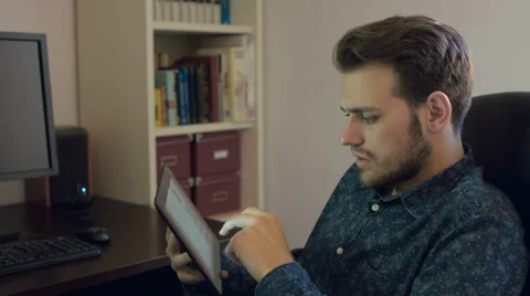 Young man using with his fingers tablet pc: browsing internet, searching, mail, Video stock 39387239