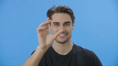 Young man using his fingers to mimic tablet manipulations Stock Footage 88399888