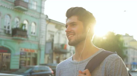 Young man using his headphones in the street Stock Footage 68599126