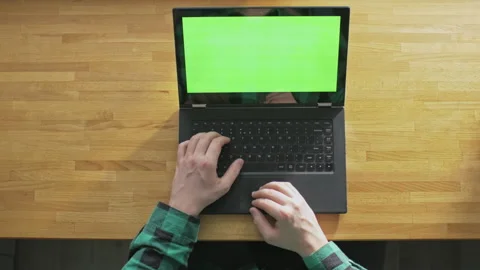 Young man using his laptop with green screen in a comfort of his home Stock Footage 143117998