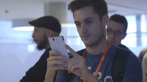 Young man using his mobile phone at business event Stock Footage 64565444