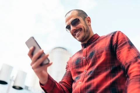 Young man using his mobile in the street. Stock Photos
