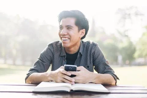 Young man using his mobile device in a park Stock Photos
