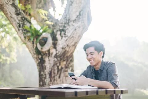 Young man using his mobile device in a park Stock-Fotos