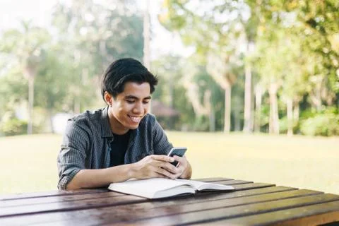 Young man using his mobile device in a park Stock Photos