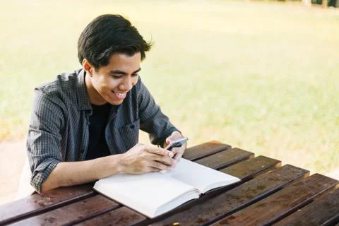 Young man using his mobile device in a park Stock Photos