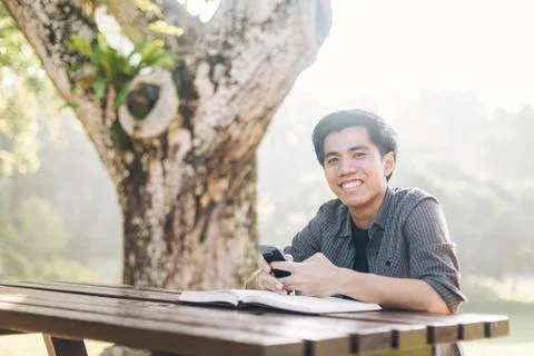 Young man using his mobile device in a park Stock Photos