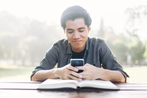 Young man using his mobile device in a park Stock Photos