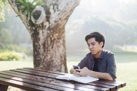 Young man using his mobile device in a park Stock Photos