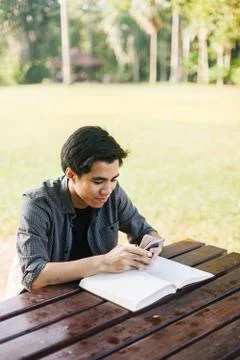 Young man using his mobile device in a park Stock Photos
