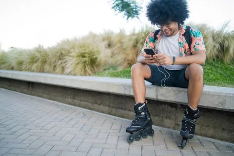 Young man using his mobile phone outdoors. Stock Photos