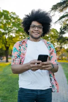 Young man using his mobile phone outdoors. Stock Photos