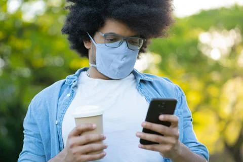 Young man using his mobile phone outdoors. Stock Photos