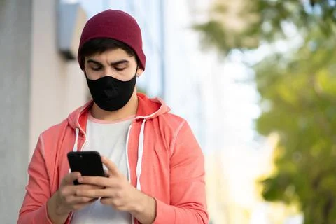 Young man using his mobile phone outdoors. Stock Photos